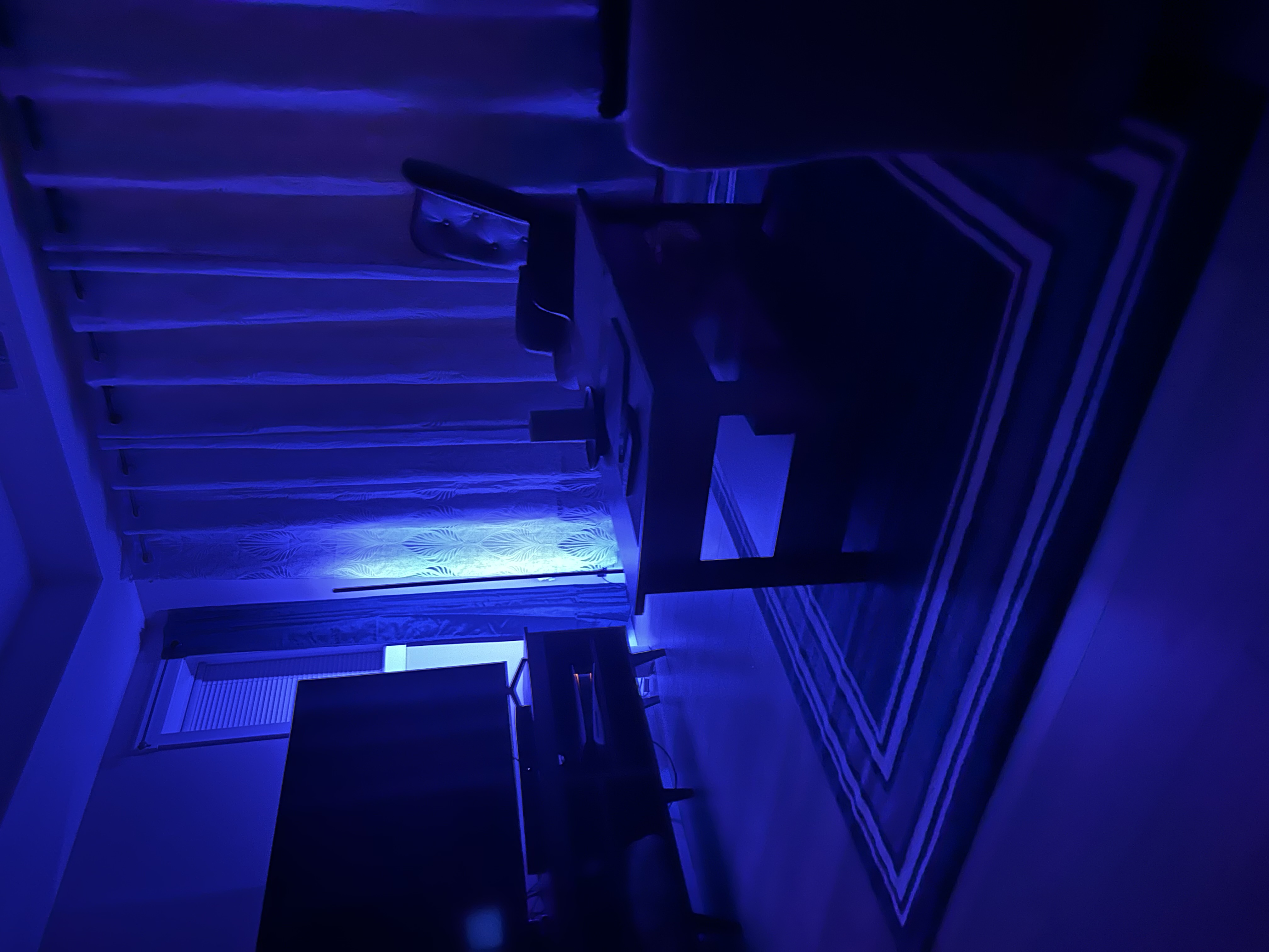 Same living room transformed with blue LED circadian lighting for evening decompression